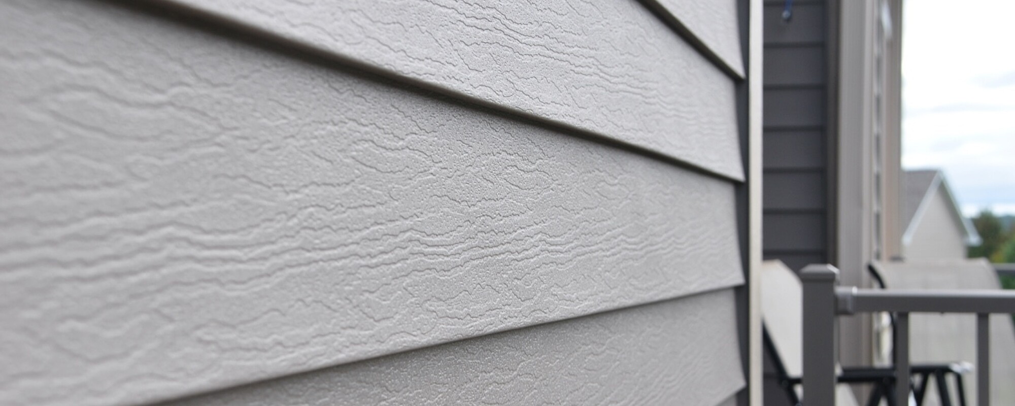 Close-up image of Klauer’s siding on a house. There is a patio area with two chairs.
