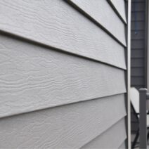 Close-up image of Klauer’s siding on a house. There is a patio area with two chairs.