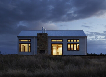 Home at night with lights on inside surrounded by dark clouds