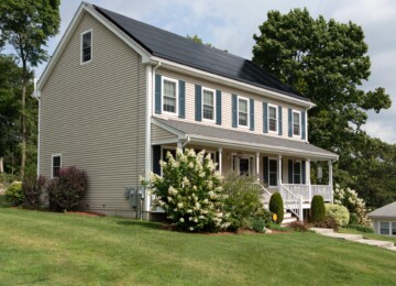 Side view of home with green shutters and landscaping